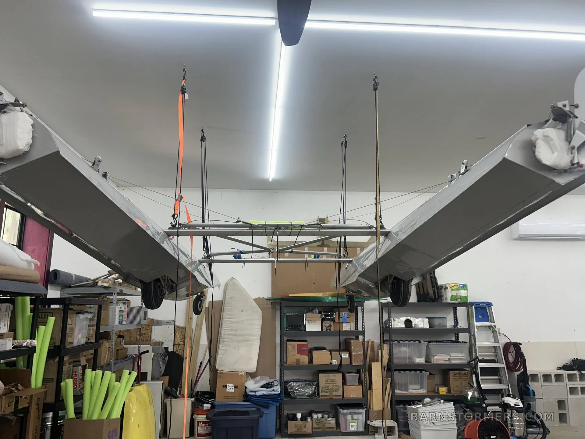 A float suspended in a workshop, surrounded by storage.