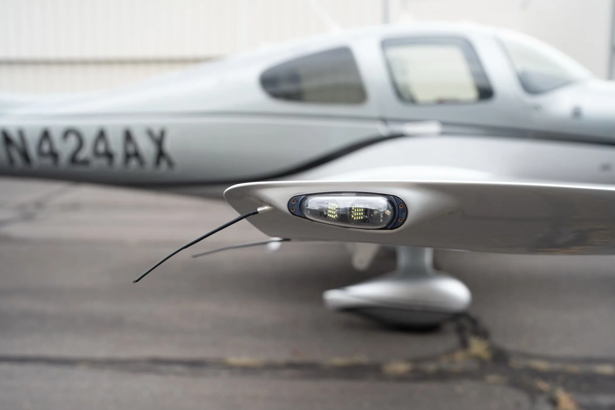 A close-up view of the wingtip light and antenna on the silver Cirrus SR22 GTS Platinum aircraft, N424AX.