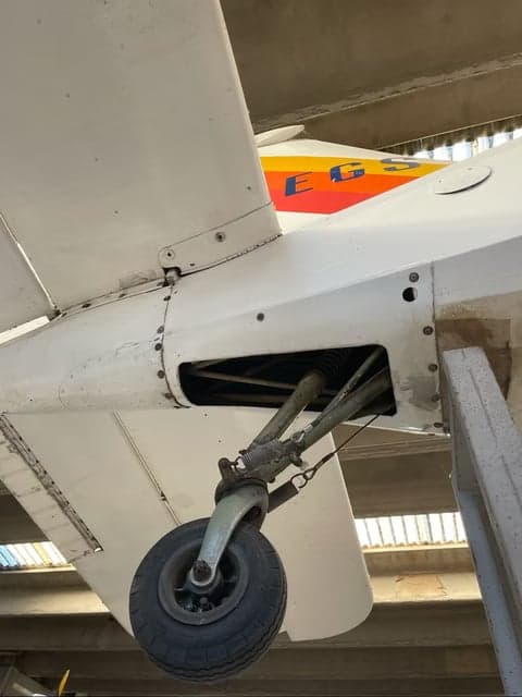I-AEGS aircraft wing and fuselage in a hangar.
