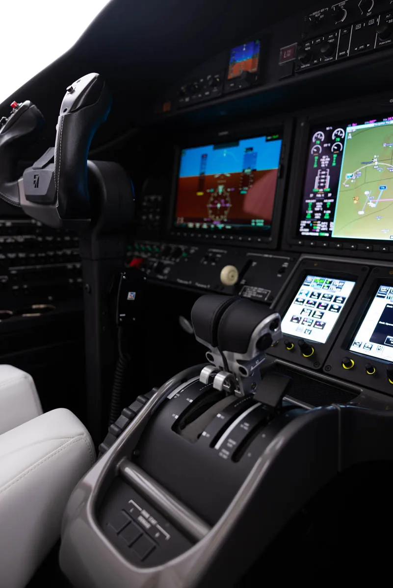 The cockpit of the Citation CJ3 with throttle controls and avionics.