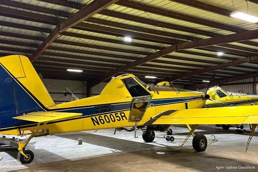 Cropduster aircraft in a hangar with yellow and blue paint scheme.