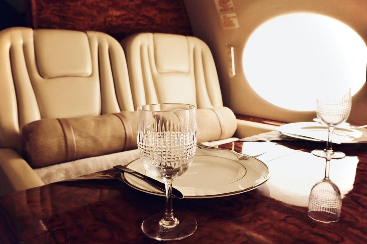 A close-up of the aircraft's interior, including a dining table set with plates and glasses.