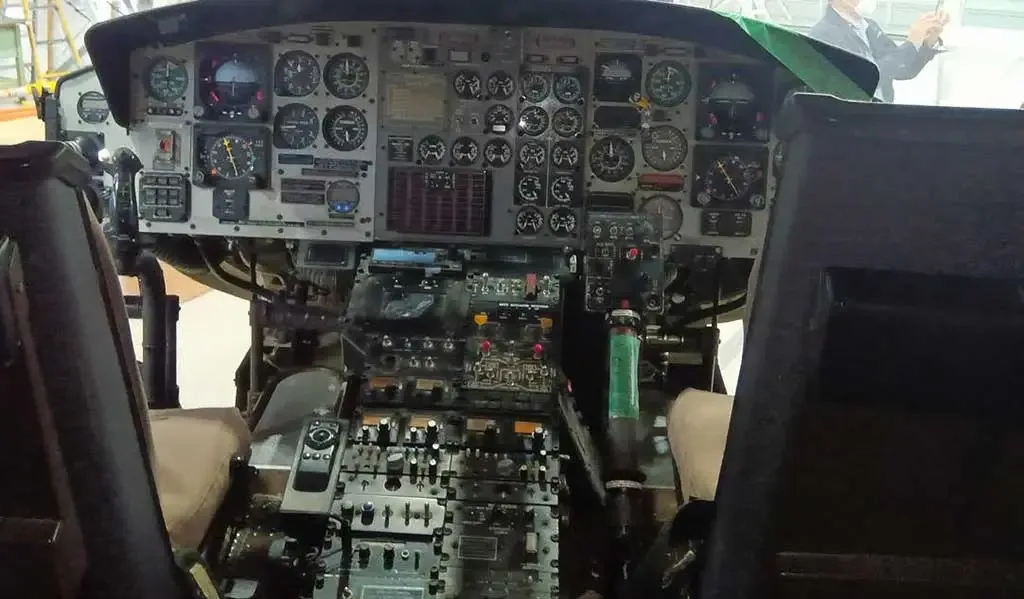 The detailed instrument panel of a helicopter, filled with various gauges and controls.