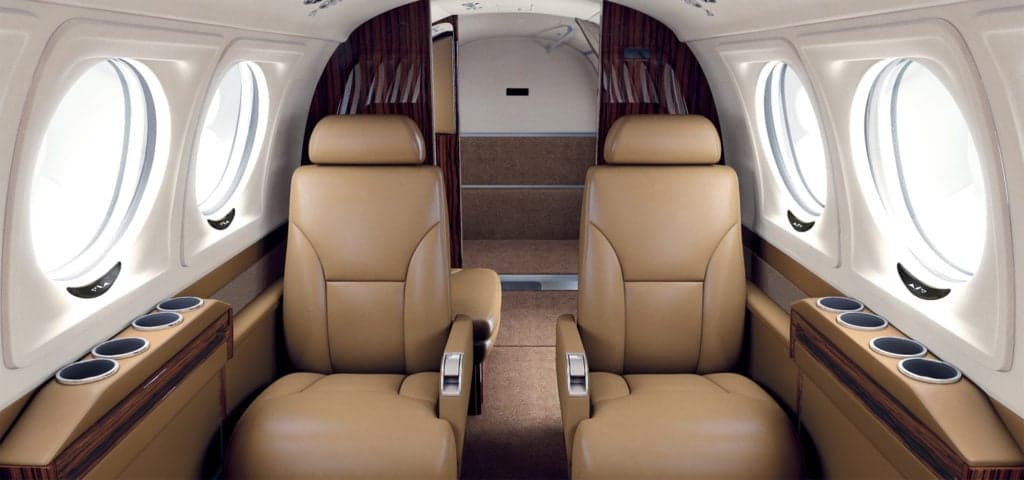 King Air 260 cabin with tan leather seats and cup holders.