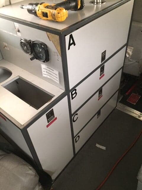 A view of the interior of the aircraft, showing a storage area with drawers labeled A, B, C, and D.