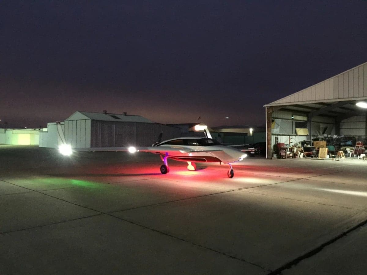 N7779X aircraft on the tarmac at night with lights on.
