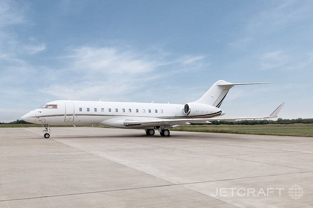 Side view of a white and gold Bombardier Global Express on the tarmac.