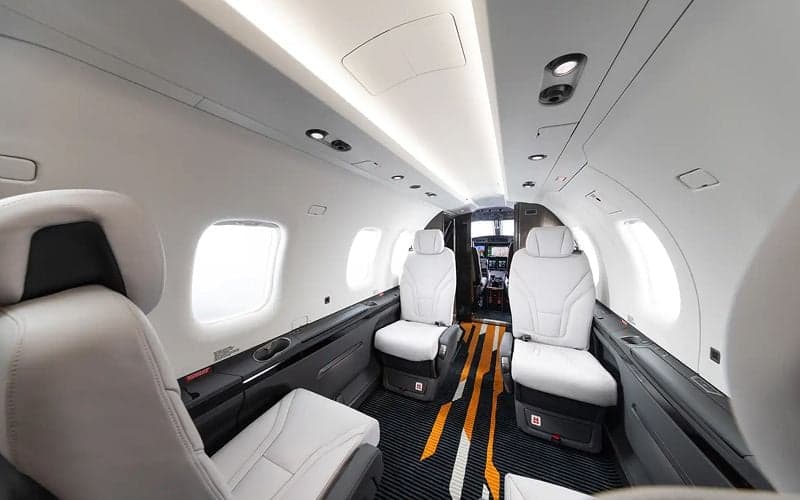 View of the Pilatus PC-12 cabin with white leather seats.