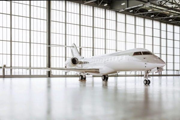 A Global Express aircraft is parked inside a hangar.