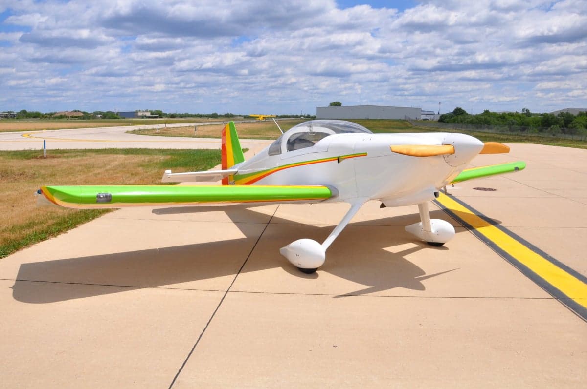 Three-quarter view of a white and colorful experimental aircraft on the tarmac.