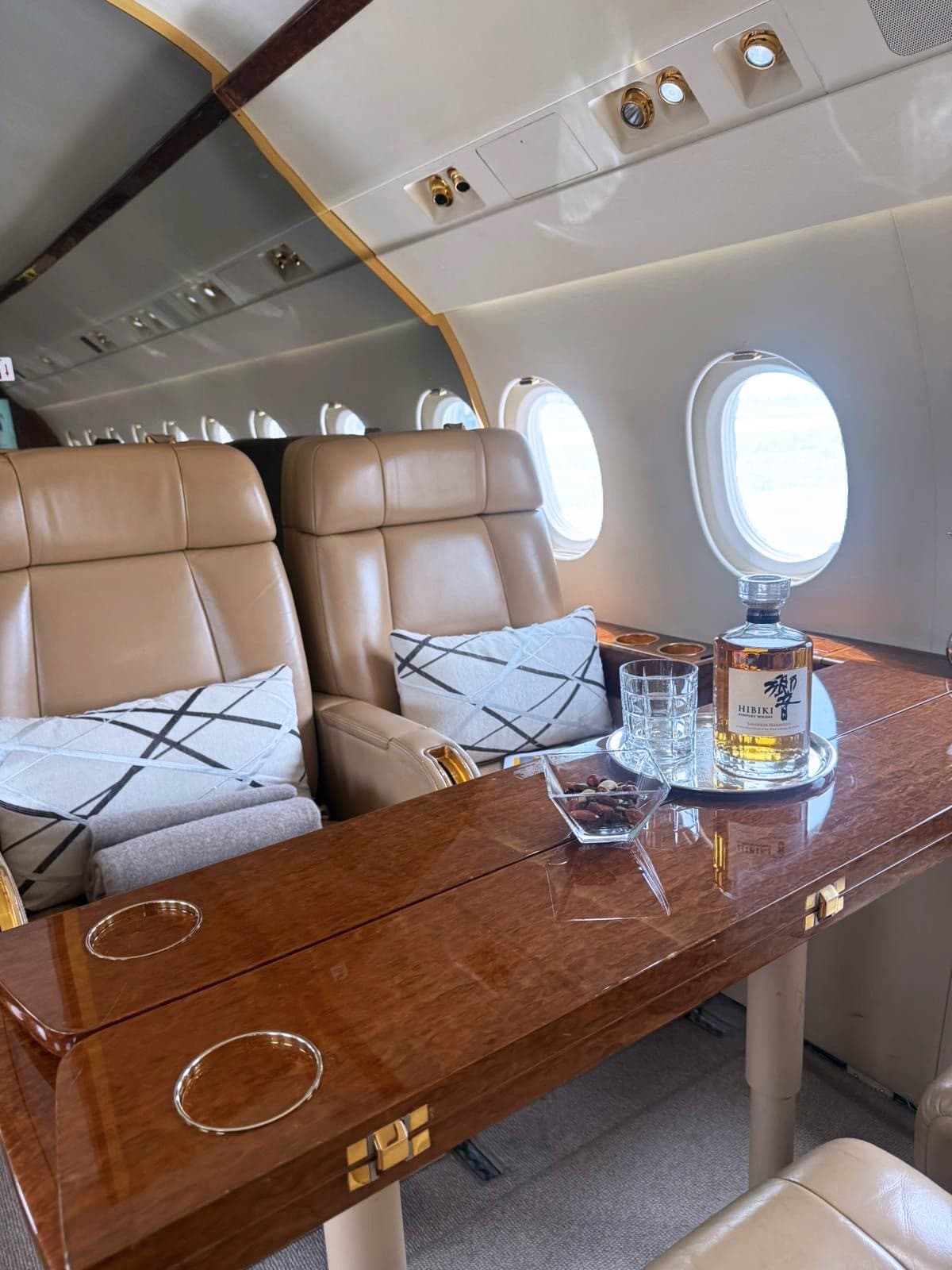 Close-up of a leather seat and wood table in the aircraft cabin.
