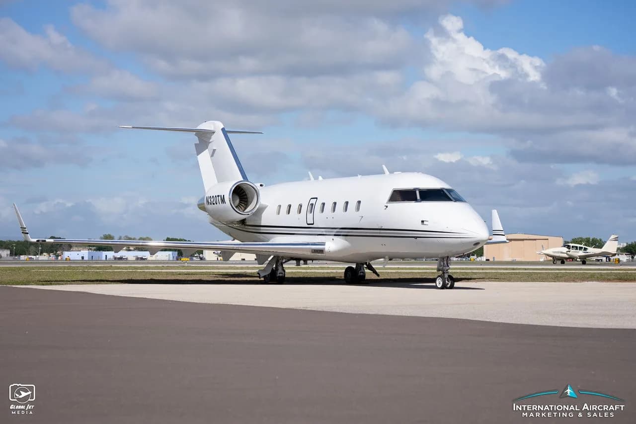 A white jet aircraft with tail number N320TM is parked on the tarmac.