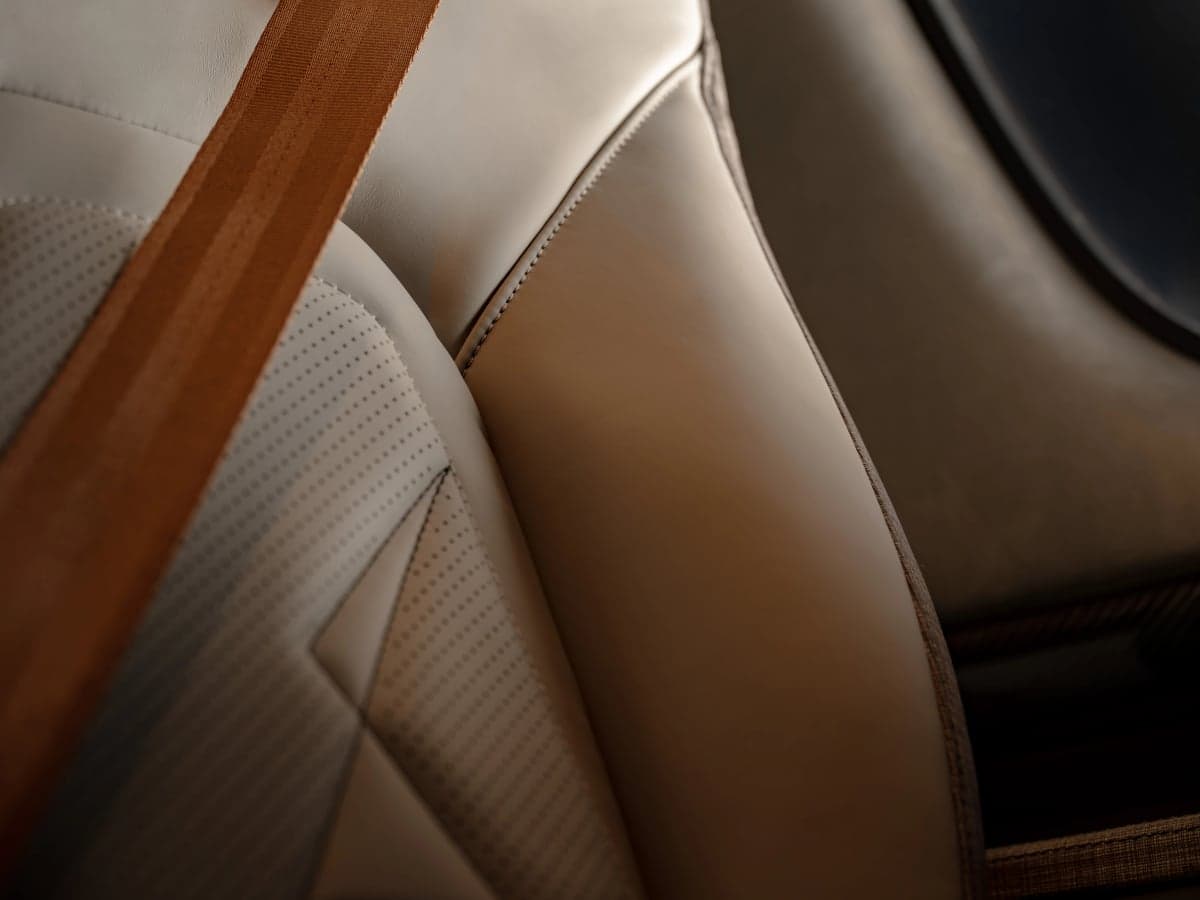 A close-up of a Cirrus aircraft seat with a brown seatbelt.