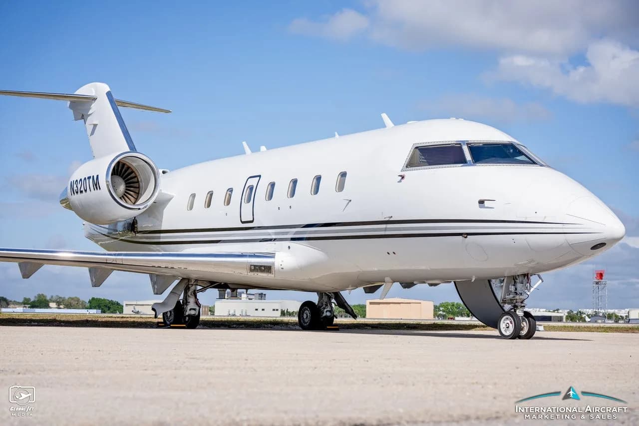 A white jet aircraft with tail number N320TM is parked on the tarmac.