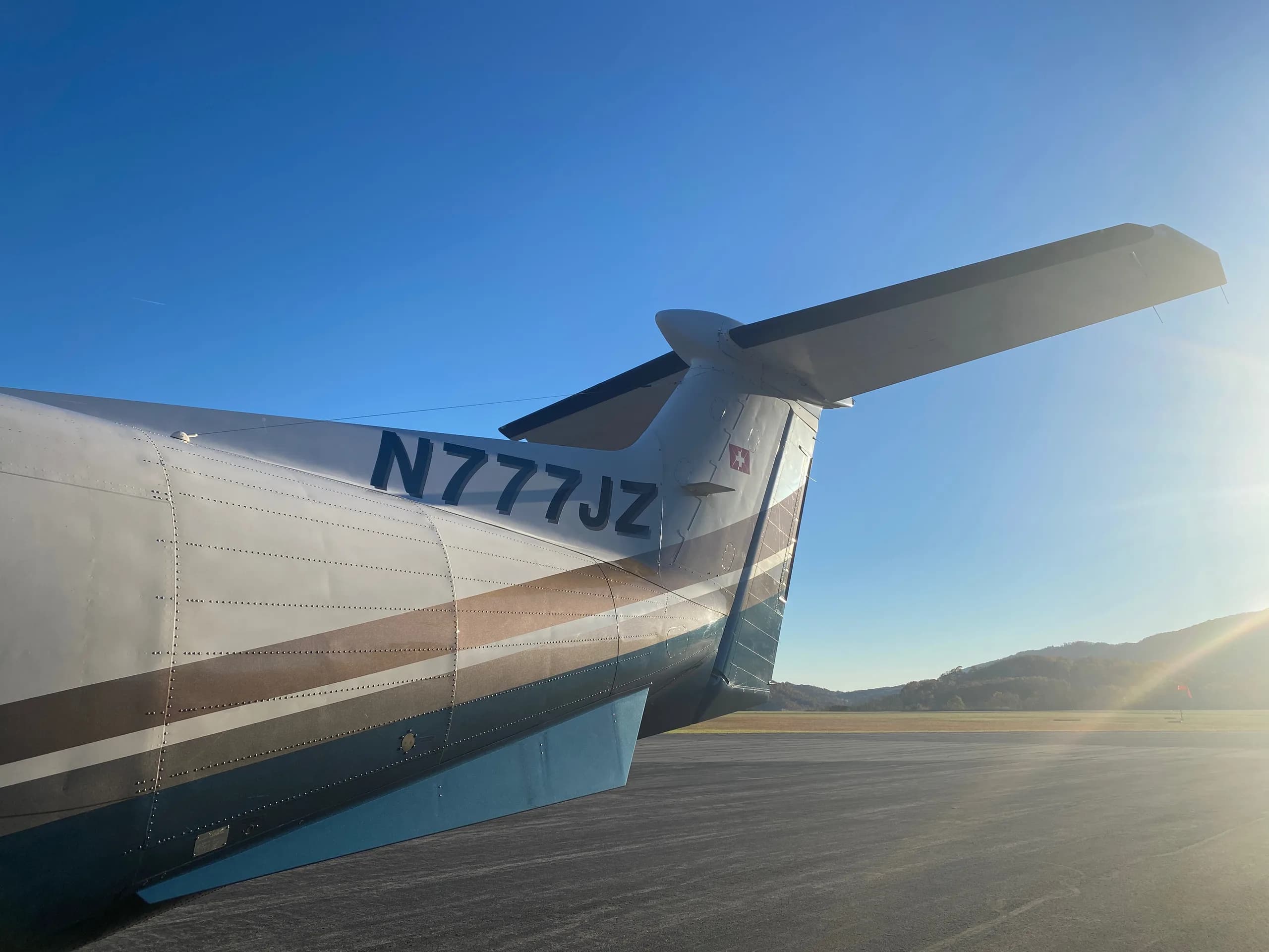 The tail of a Pilatus PC-12 aircraft with registration N777JZ is visible.