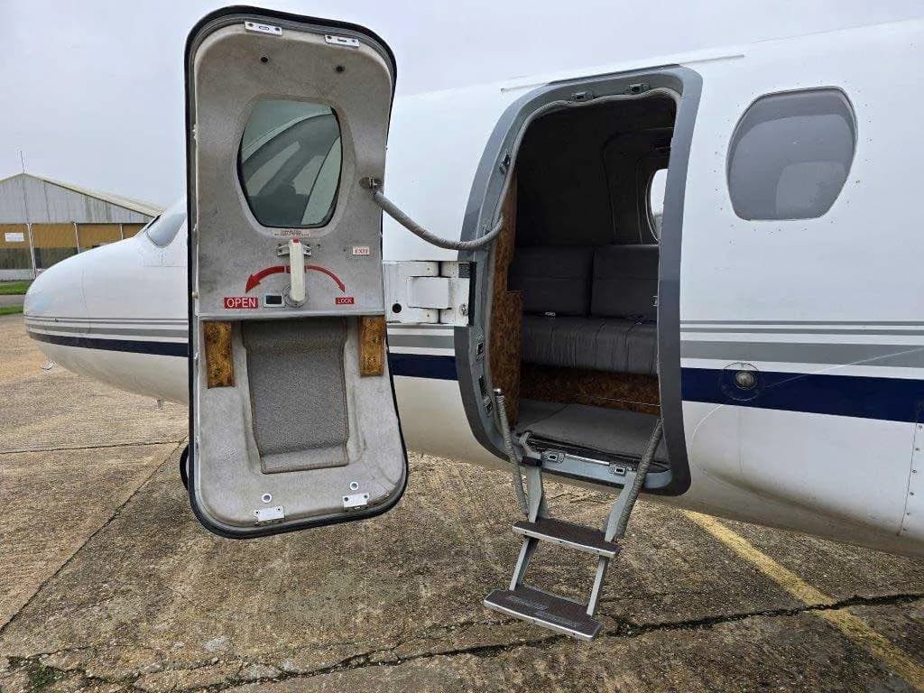 A close-up view of the open main entry door and retractable steps of a white Cessna Citation jet.