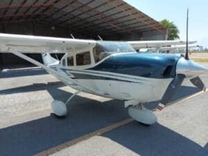 Close-up of the front of a Cessna aircraft with blue and white paint scheme, parked on the tarmac.