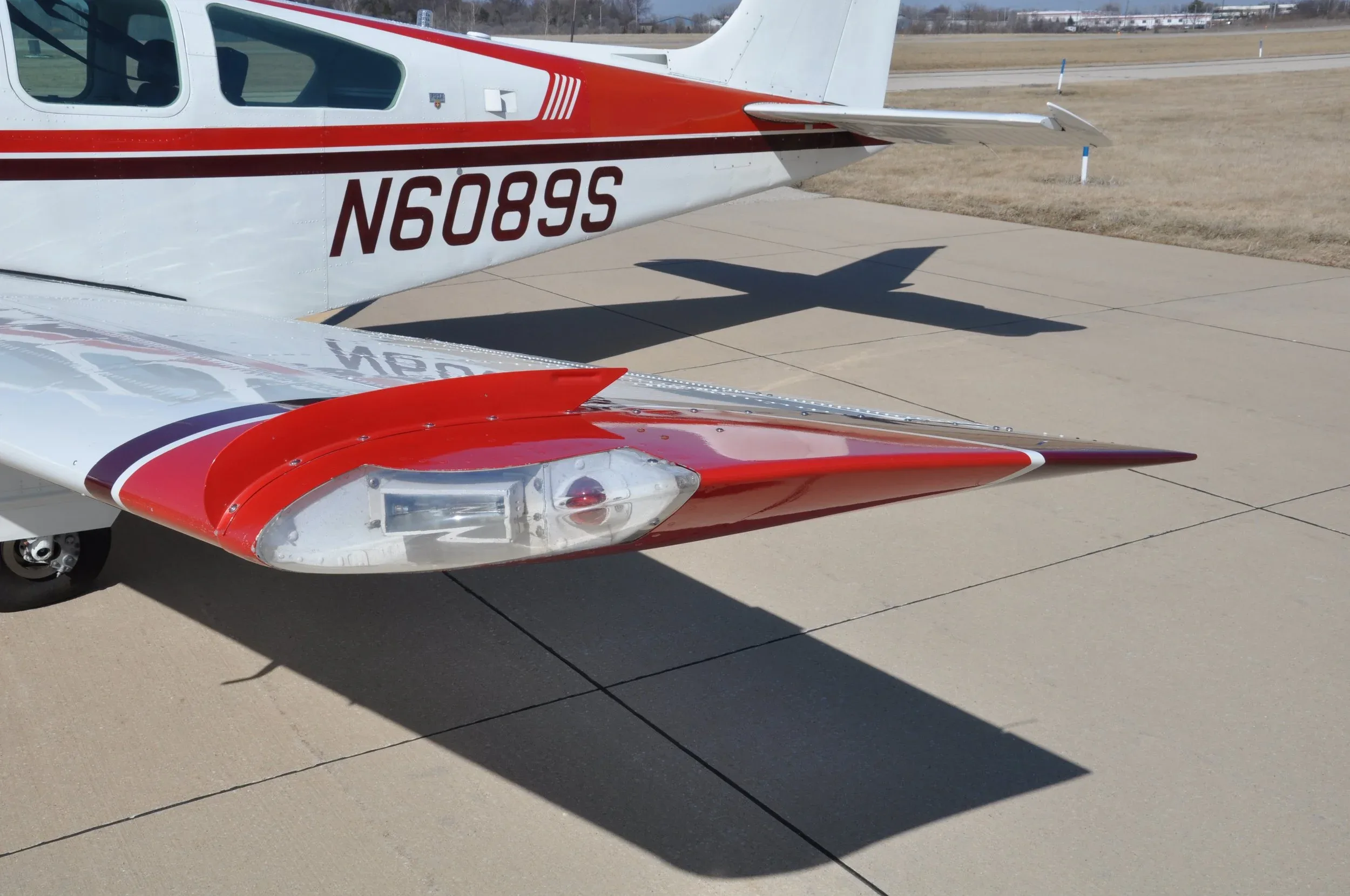 A close-up of the aircraft's right wingtip with a clear navigation light and the N6089S registration on the tail.