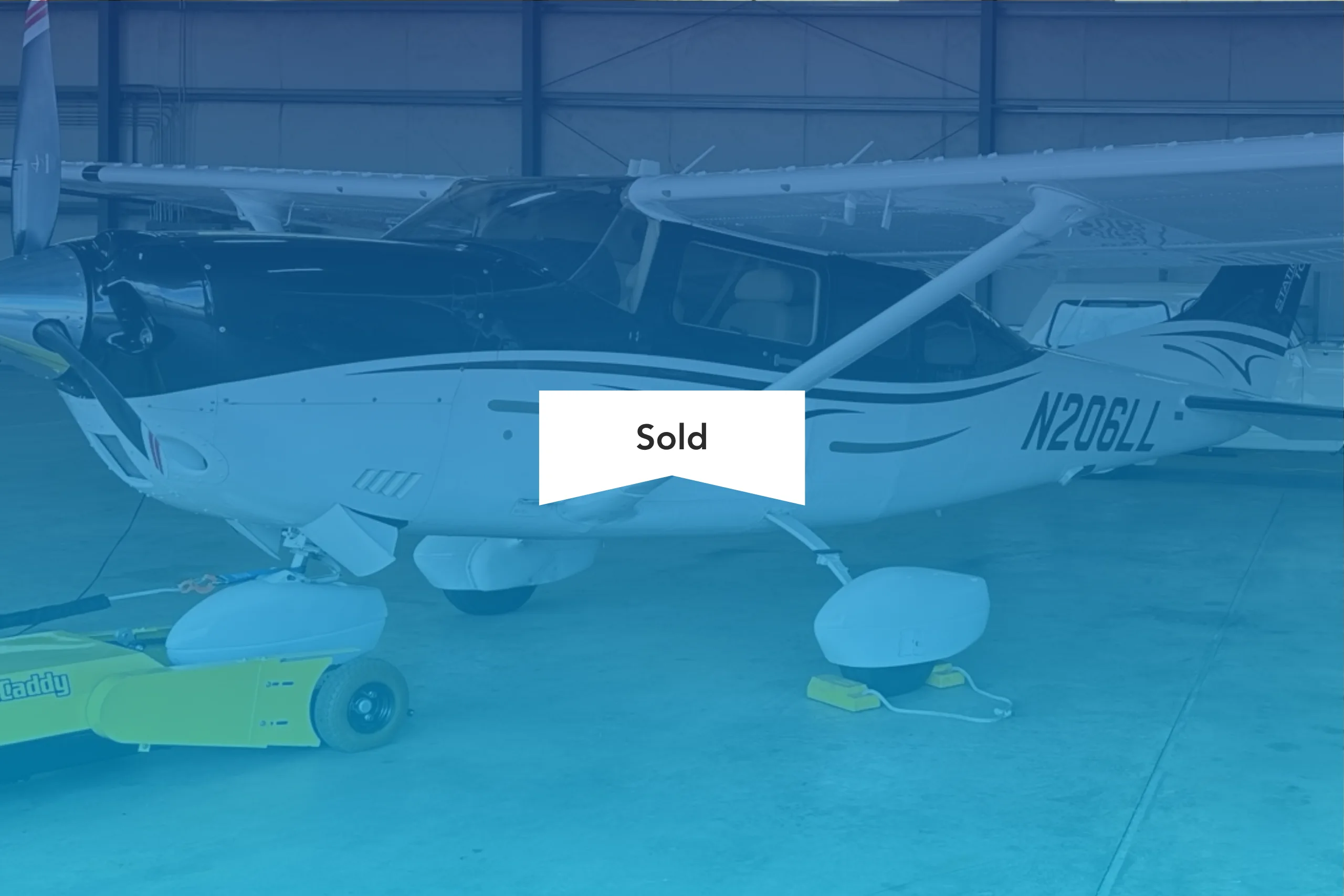 Cessna 206 Stationair aircraft N206LL parked in a hangar with a SOLD banner overlay.