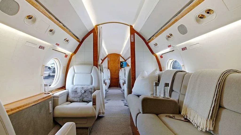 A view of the private jet's cabin interior featuring plush seating and a comfortable couch.