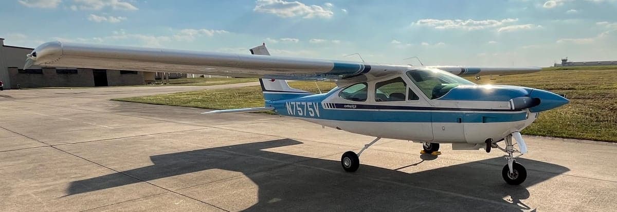A Cessna Cardinal RG, registration N7575V, parked on the tarmac with a blue and white paint scheme on a sunny day.