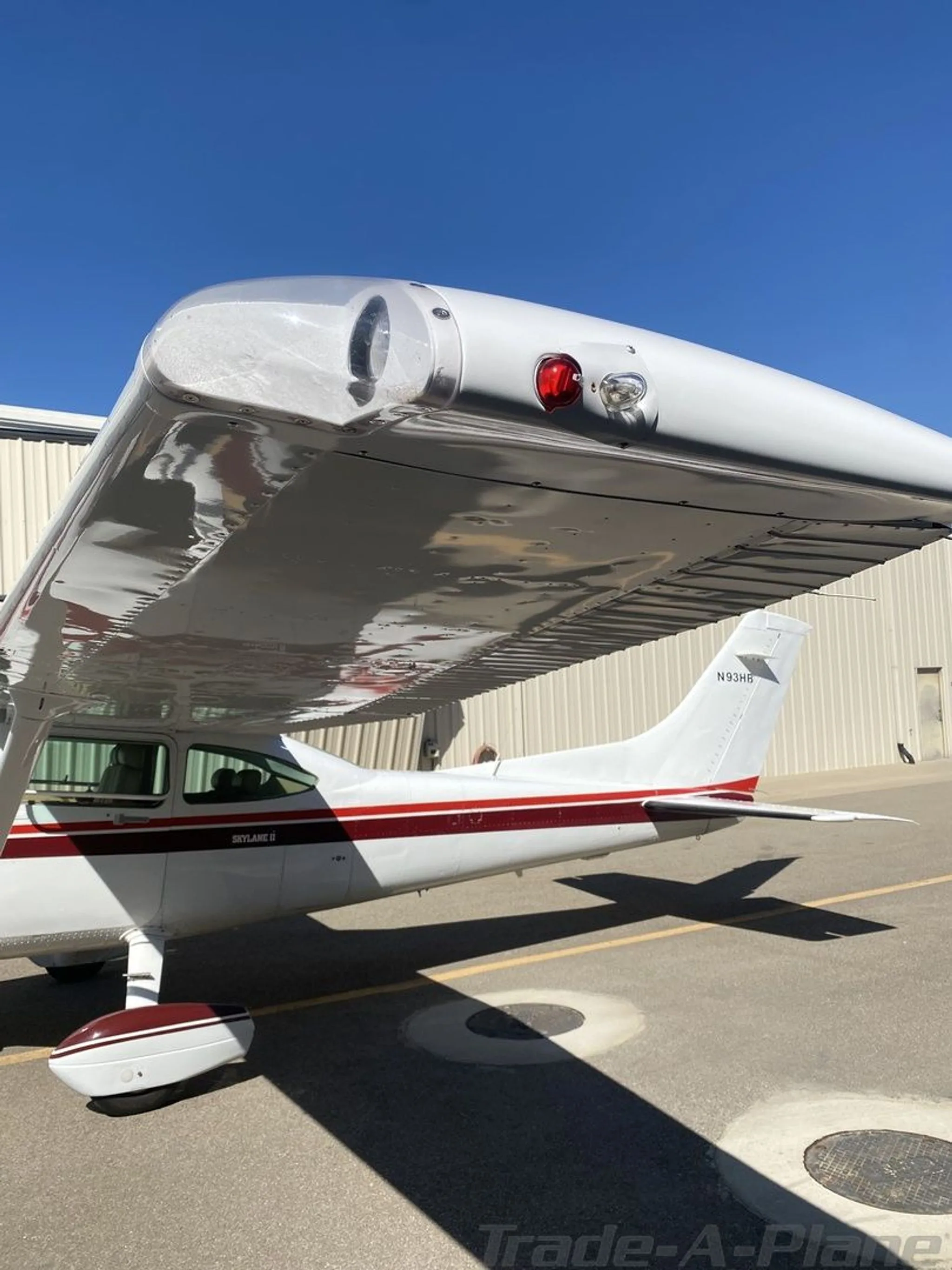 A close-up view of the right wingtip and tail of the Cessna 182, showing the N93HB registration and "Skylane II" text.