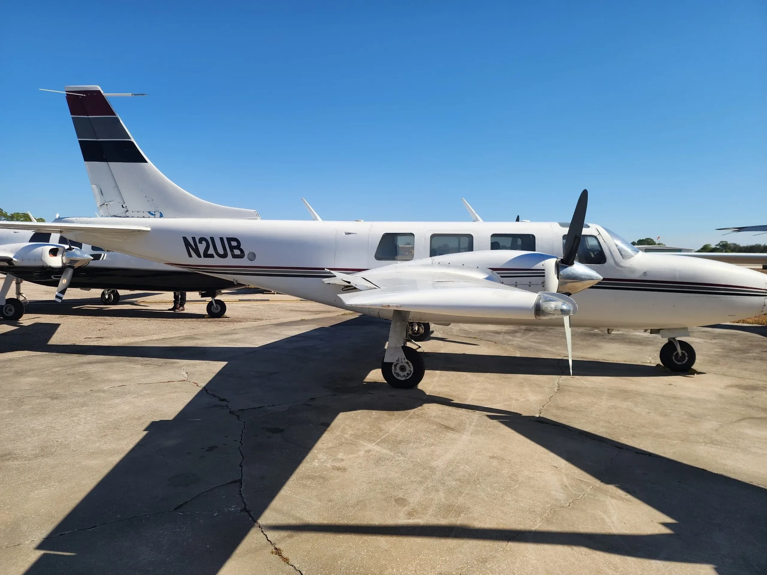 Side view of the N2UB aircraft with white and black paint scheme parked on an airfield.