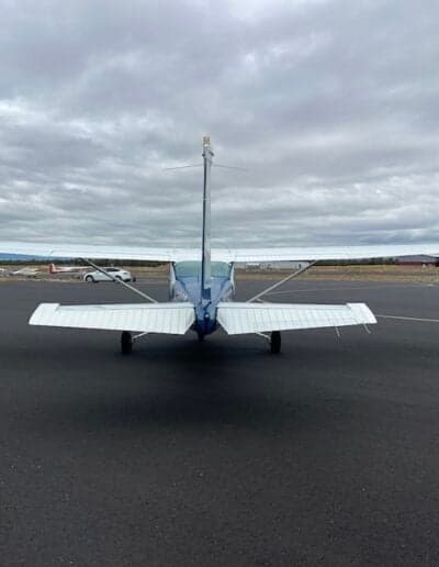 Rear view of the aircraft on the tarmac, showing the tail and wings.