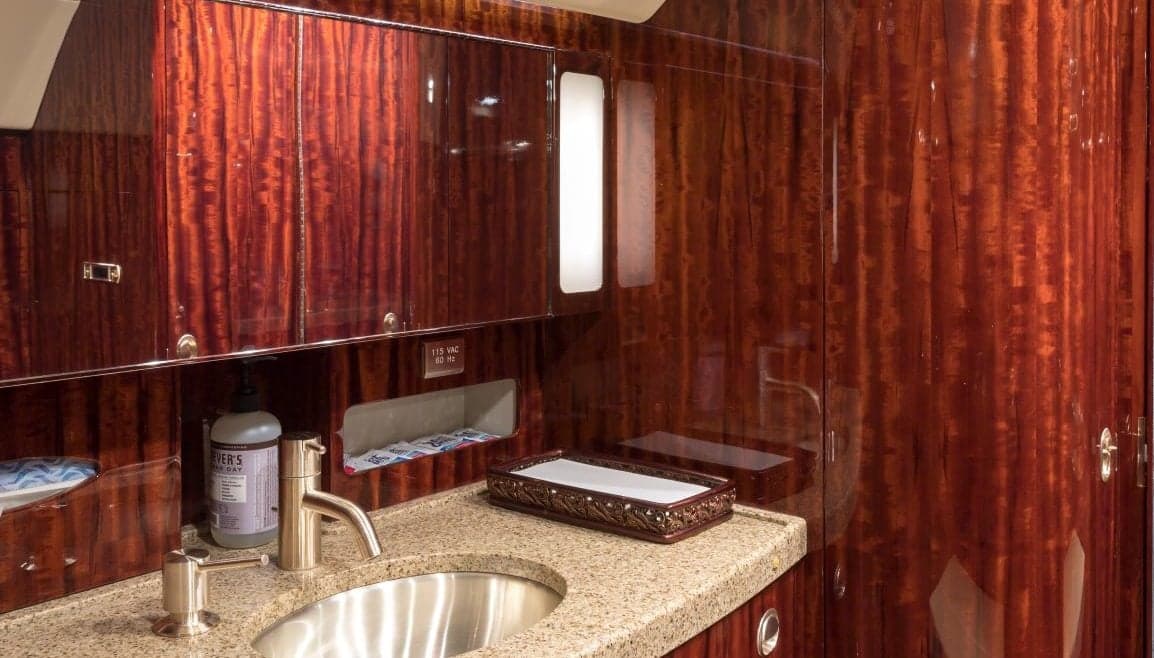 The aircraft's lavatory features a sink and wood paneling.