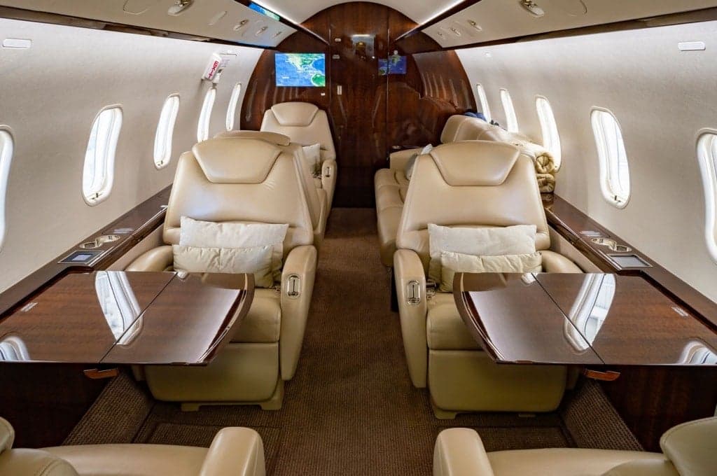 Interior view of the aircraft cabin with leather seats and wood trim.