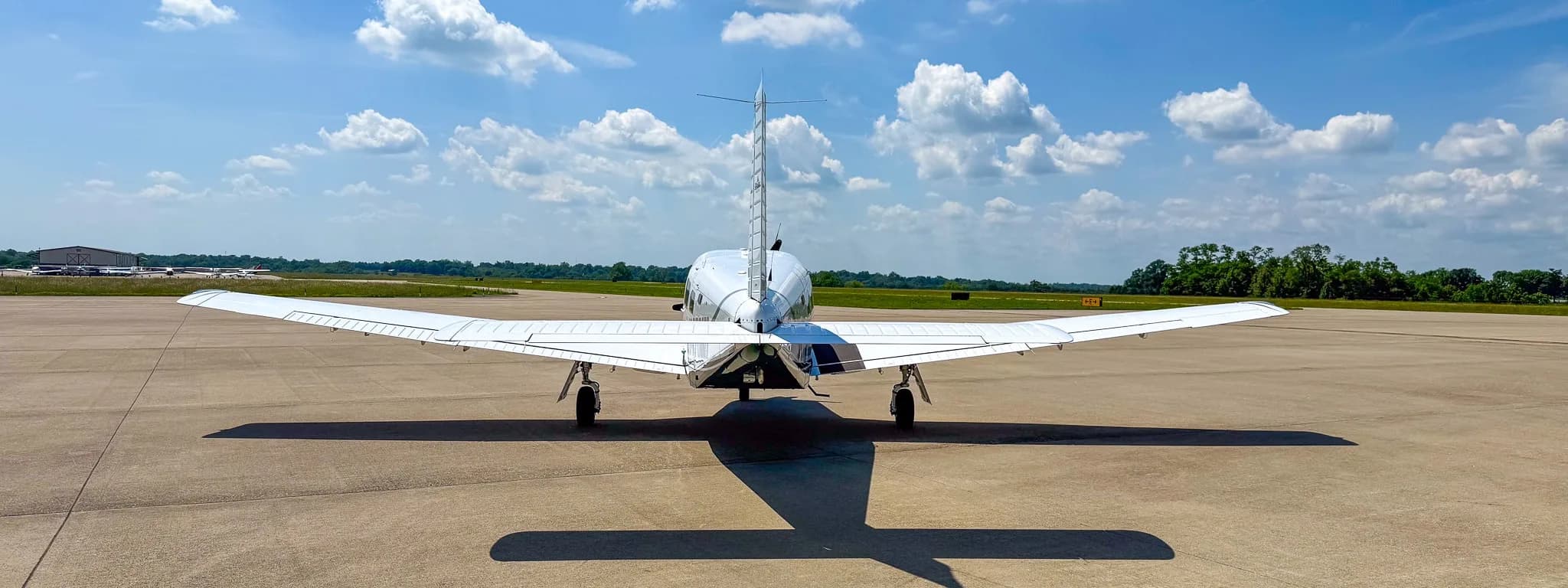 A rear view of the white Piper Saratoga II TC aircraft (N478MD) parked on an airfield.