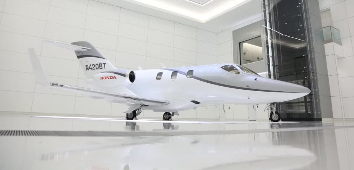 A HondaJet aircraft with registration N420BT is parked inside a hangar.