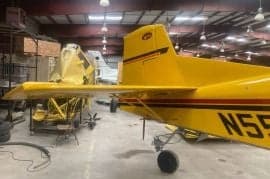 The tail of a yellow agricultural aircraft with tail number N55.