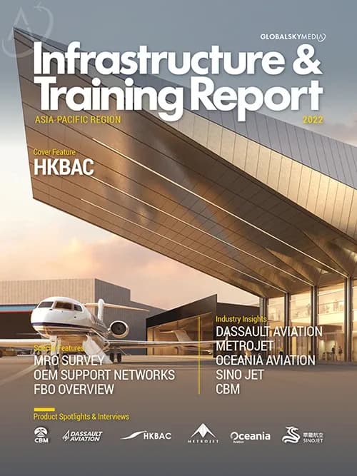 A white business jet is parked on the tarmac in front of a modern, glass-fronted hangar.