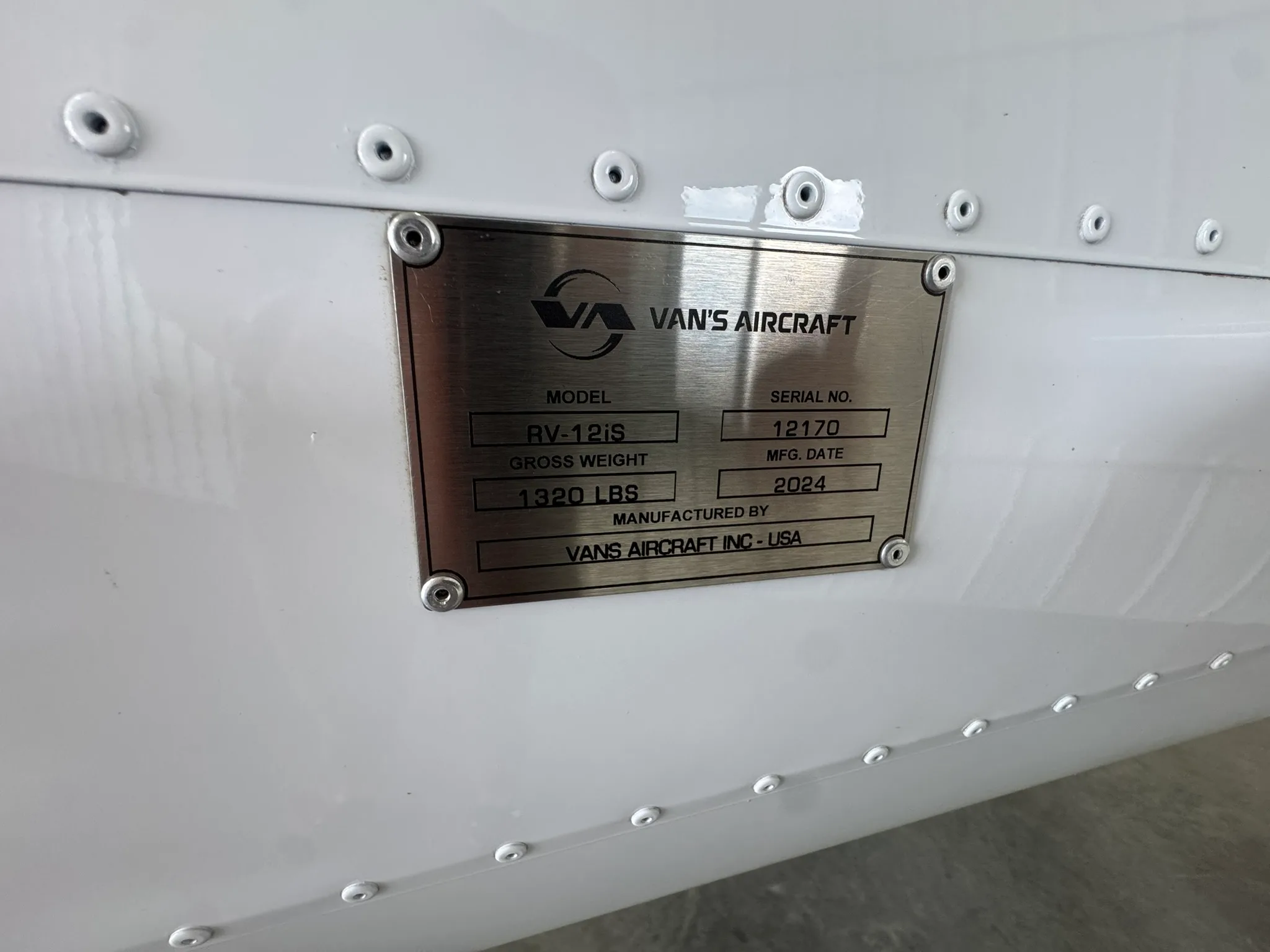 A close-up of the Van's Aircraft data plate, showing model RV-12iS, serial no. 12170, and mfg. date 2024.