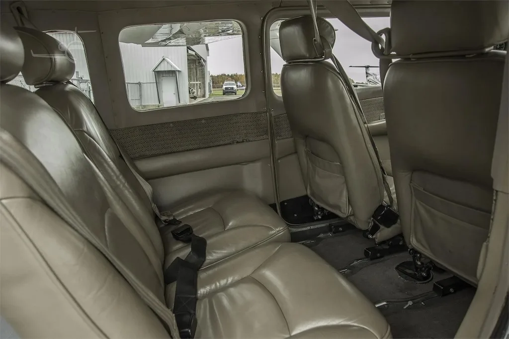 A view of the tan leather rear seats and the cabin interior, looking towards the front of the aircraft.