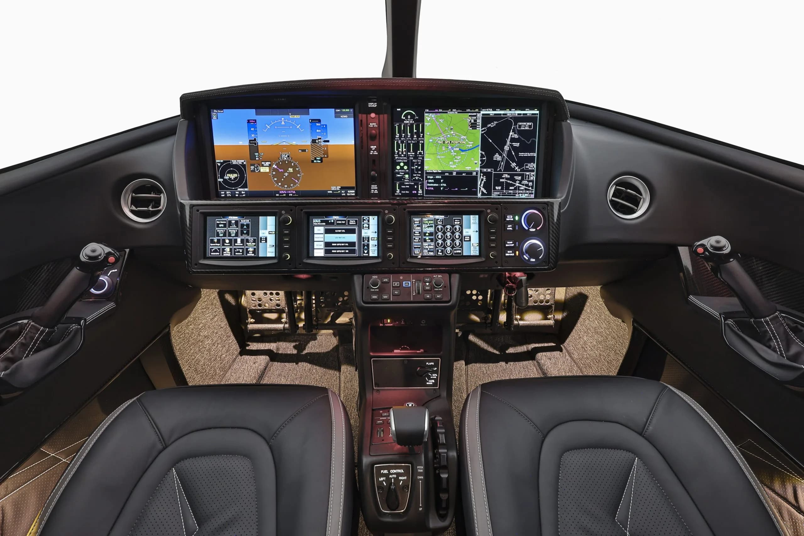 The modern glass cockpit of a Cirrus Vision Jet features multiple large digital displays and side-stick controls.