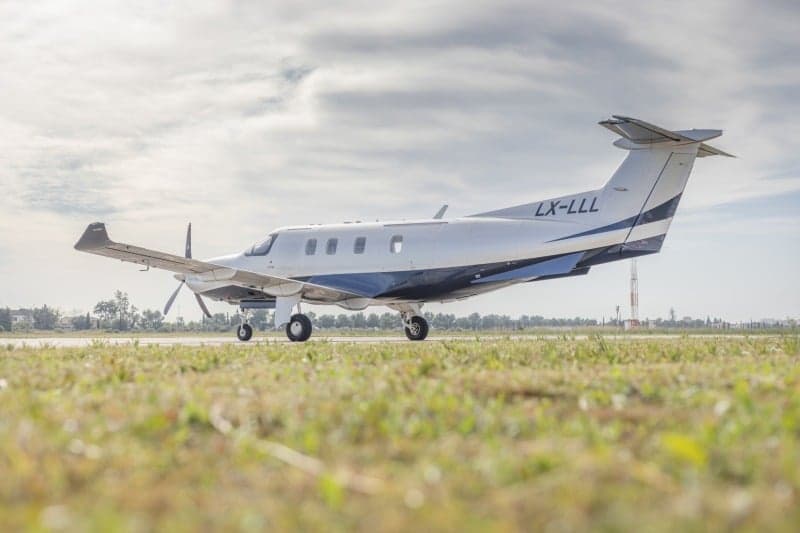 A Pilatus PC-12 aircraft with registration LX-LLL parked on the tarmac.