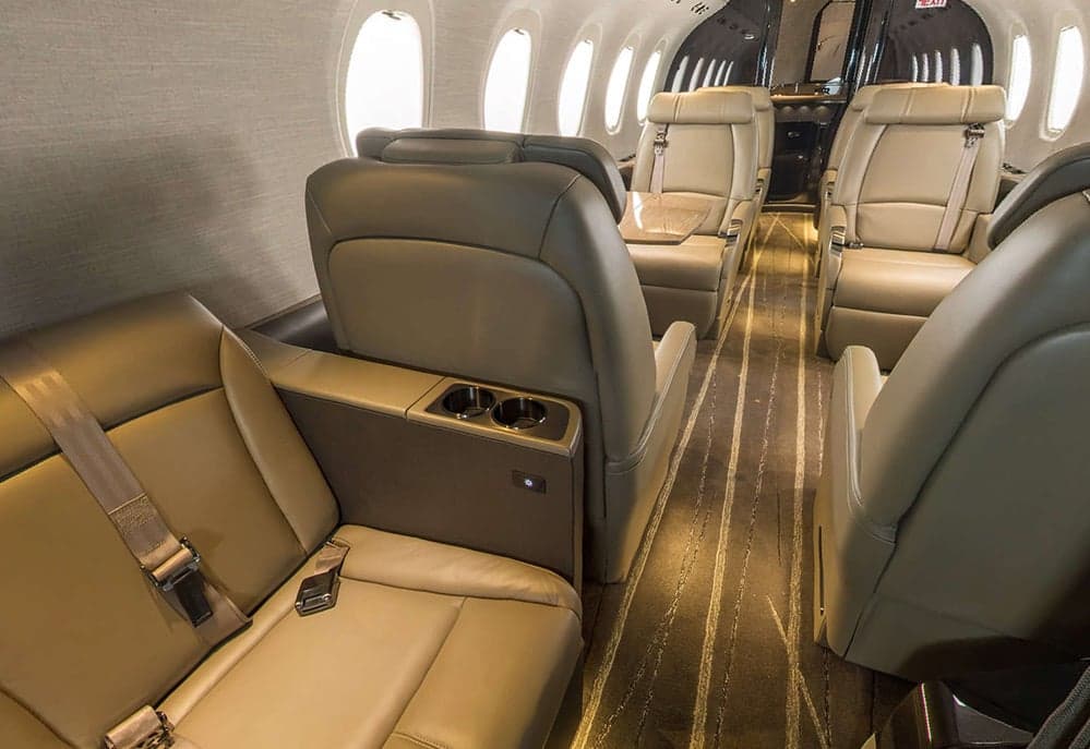A view of the Citation Latitude cabin with tan leather seats and cup holders.