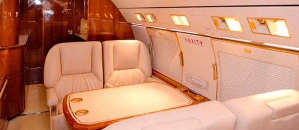 Interior of the aircraft with cream-colored seats and wood accents.