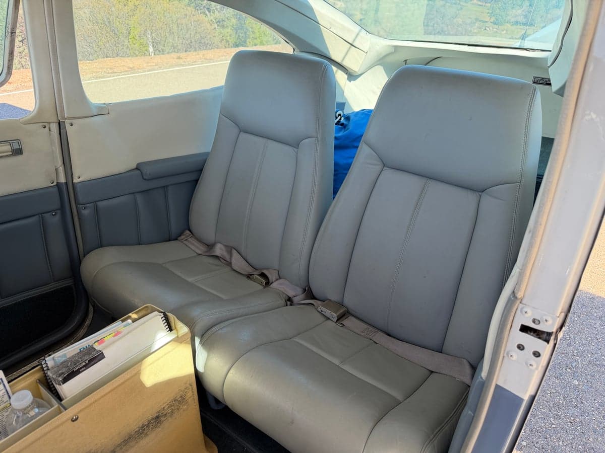 The aircraft's interior features two gray leather seats in the front.