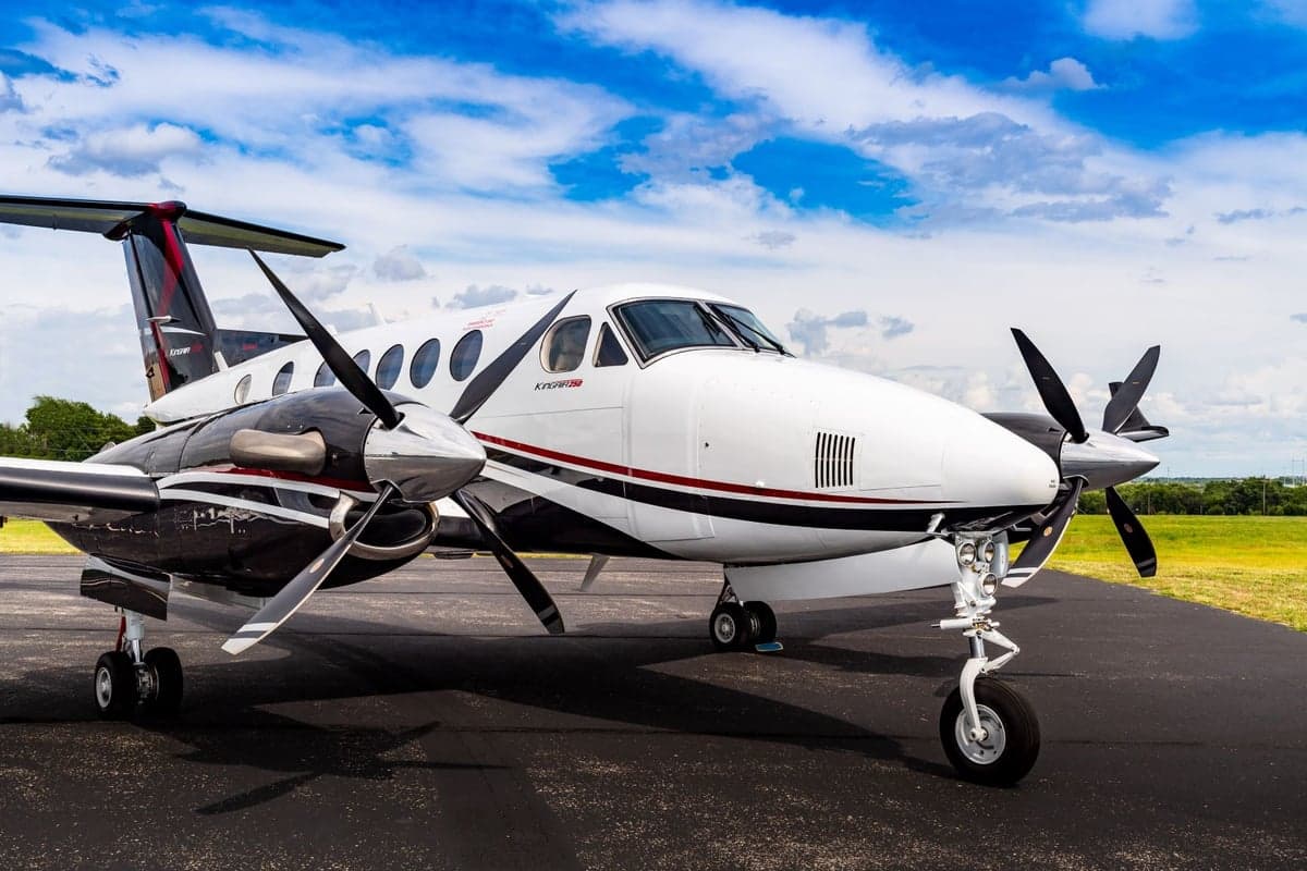 King Air 250 aircraft parked on the tarmac with a blue sky background.