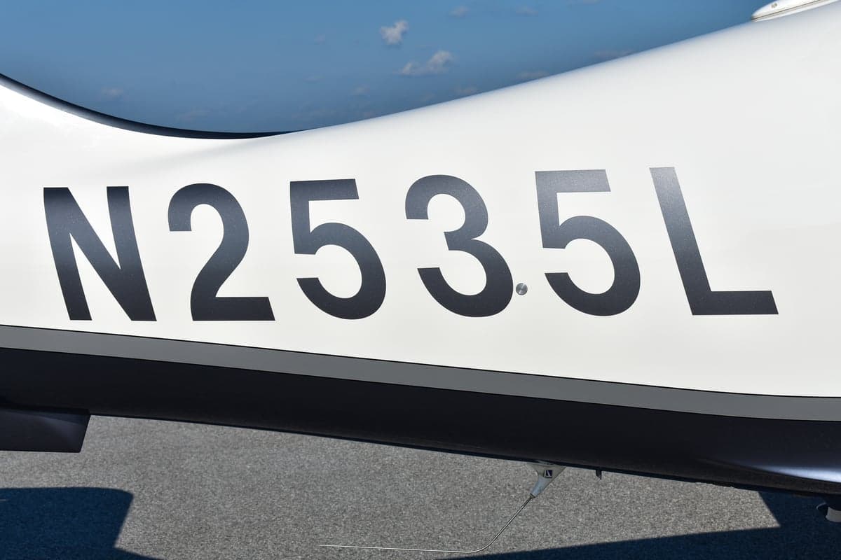 Side view of a Lancair Columbia 400 aircraft with tail number N2535L on the tarmac.