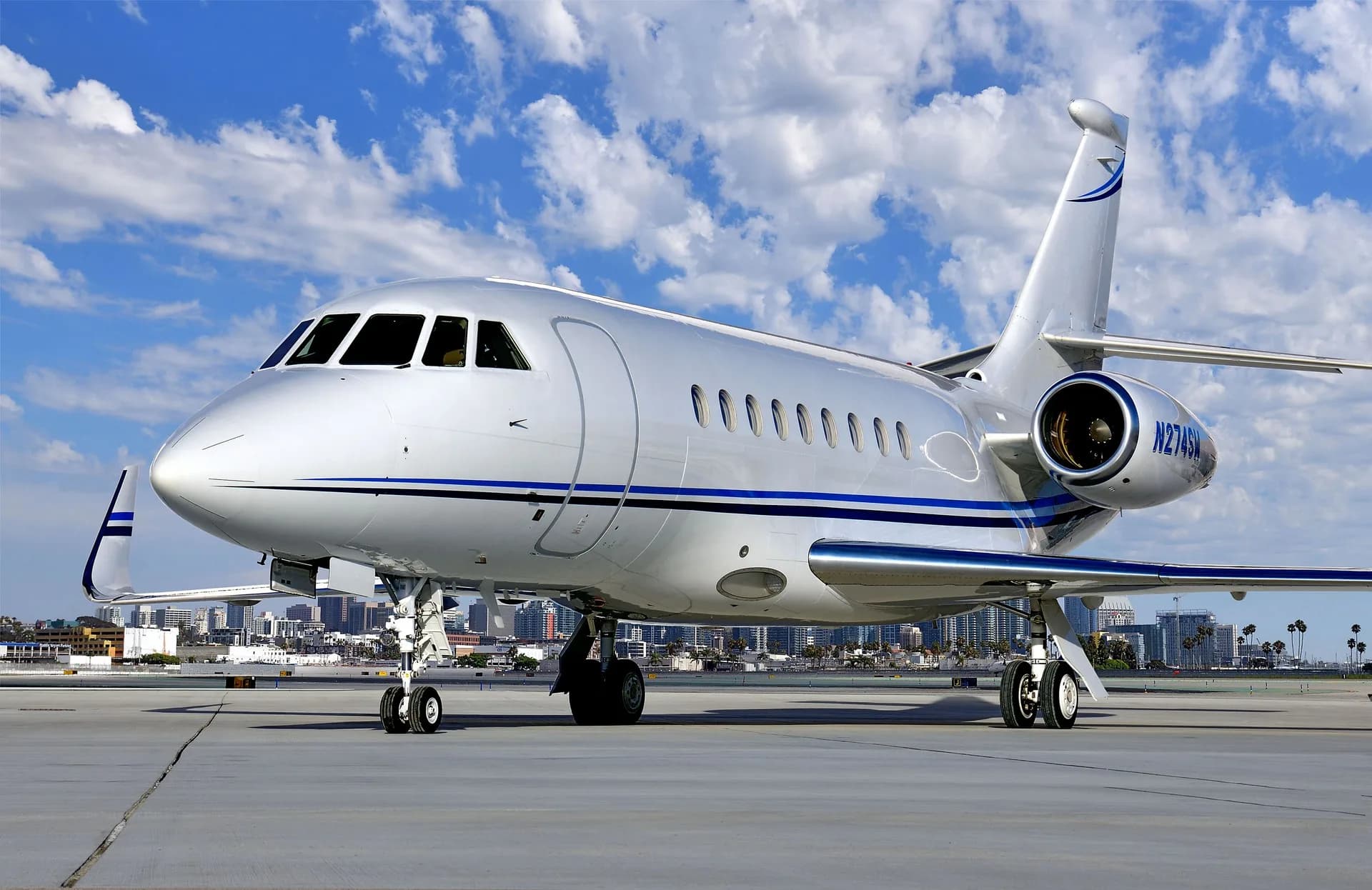 Exterior view of the aircraft on the tarmac with the city skyline in the background.
