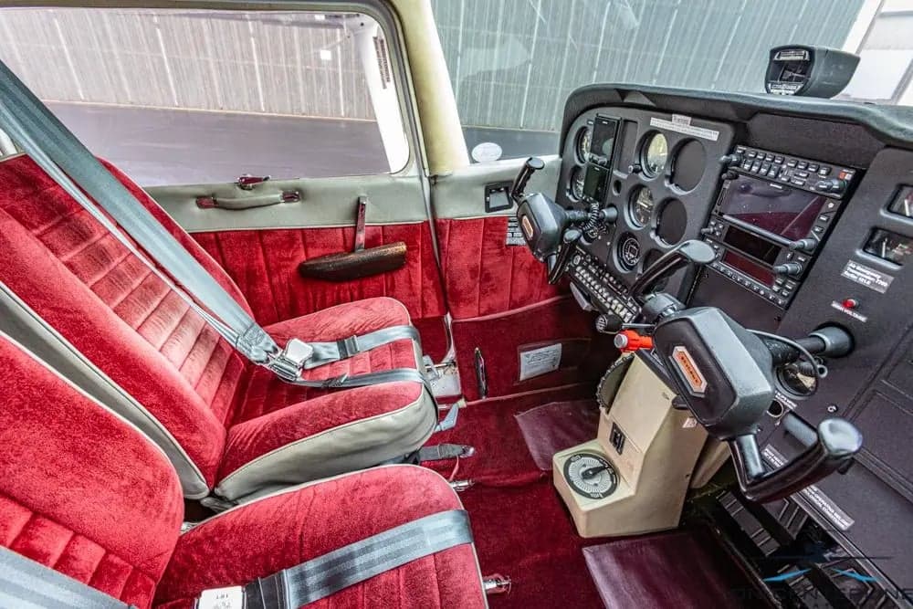 View of the Cessna 172 Skyhawk cabin, showing the red seats and cockpit.