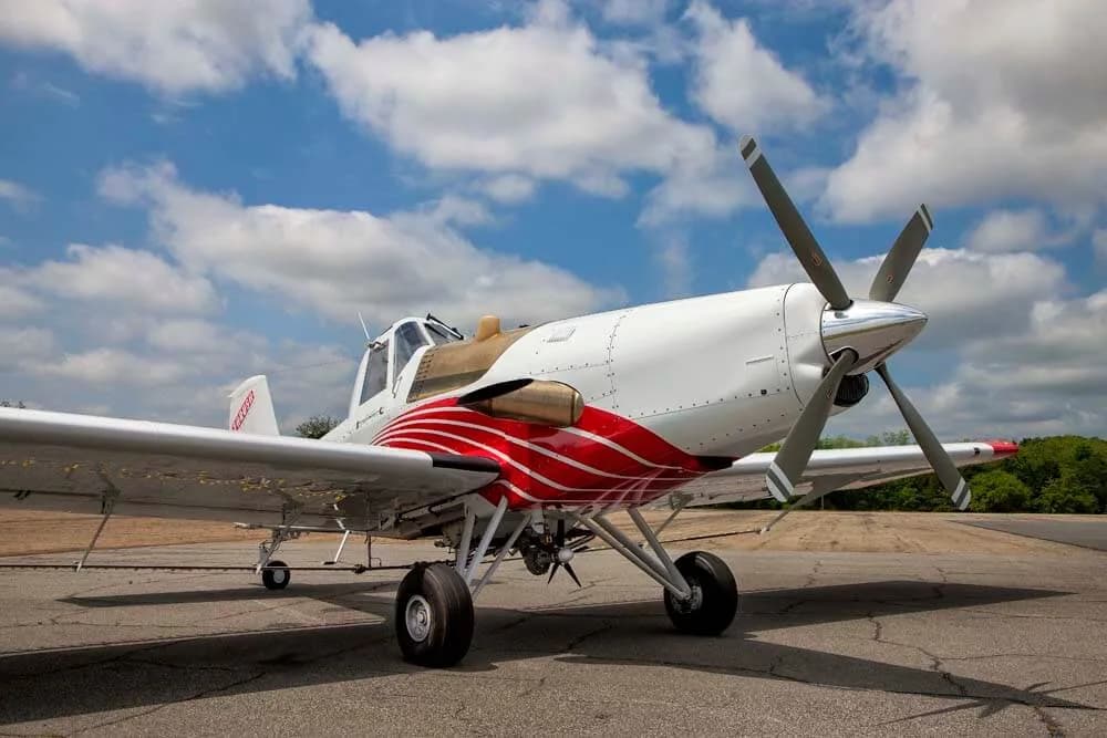 Air Tractor crop duster parked on the tarmac with a red and white paint scheme.
