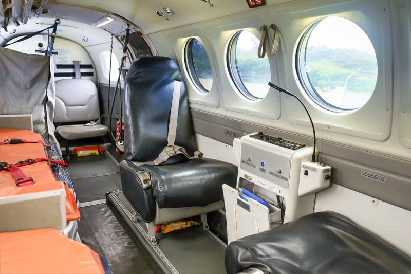 Aircraft interior with seats and medical equipment.