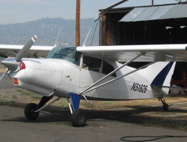 A white and blue Maule M-5-235C, registration N51626, parked near a hangar.