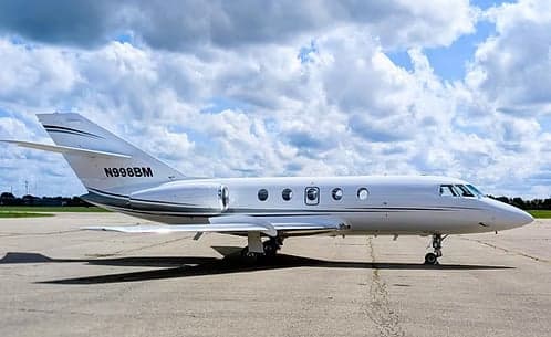 Side view of a Hawker jet with registration N998BM parked on the tarmac.