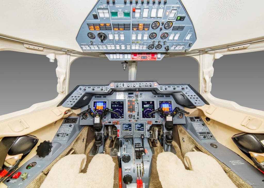 Close up of the engine and fuselage of a white aircraft.
